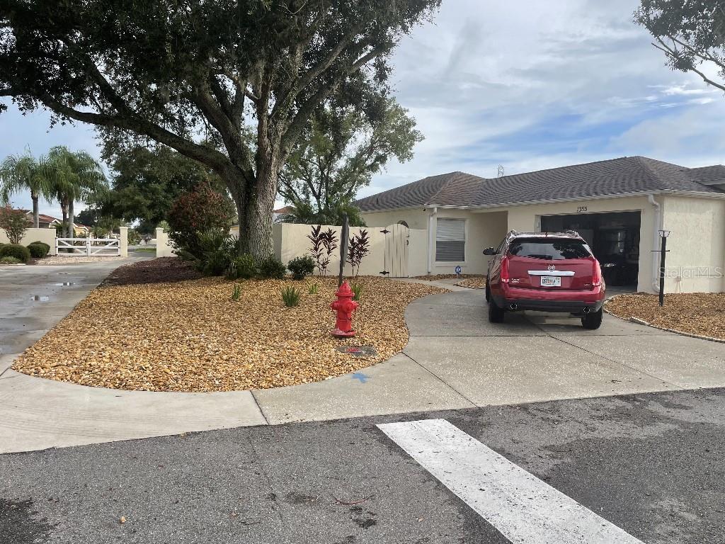 single story home featuring stucco siding, concrete driveway, an attached garage, a gate, and fence