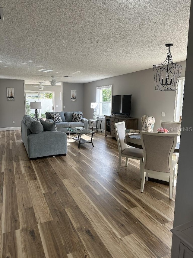 living area with visible vents, dark wood finished floors, a textured ceiling, and an inviting chandelier