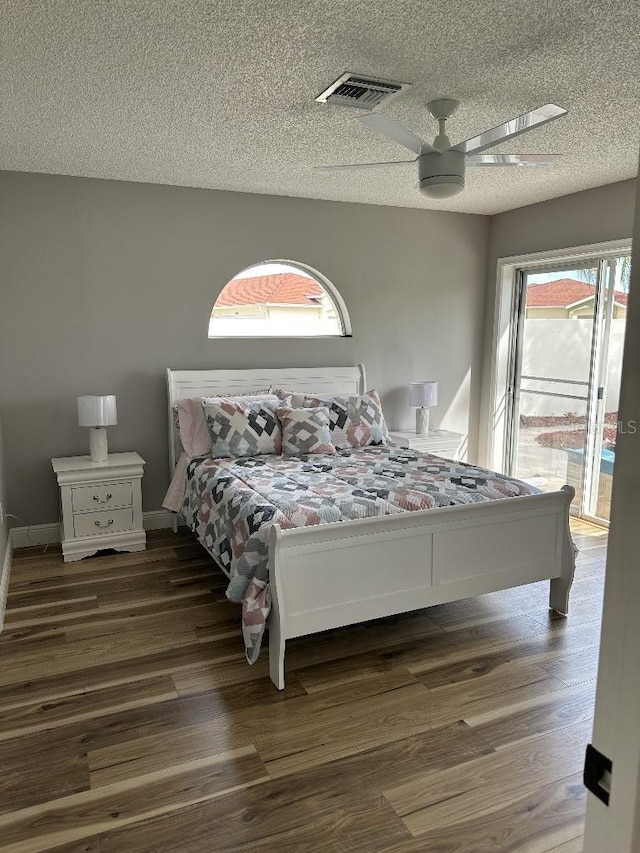 bedroom featuring access to exterior, multiple windows, and wood finished floors