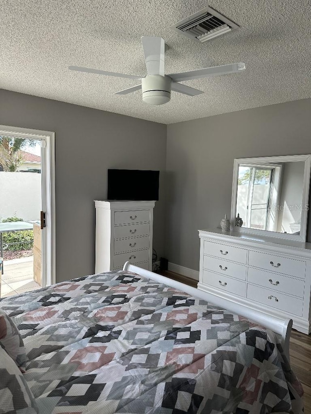 bedroom with vaulted ceiling, multiple windows, a textured ceiling, and visible vents