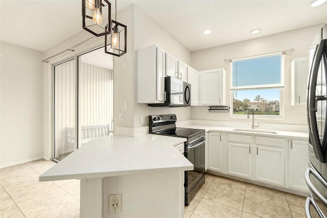 kitchen with decorative light fixtures, light countertops, white cabinets, a sink, and black appliances