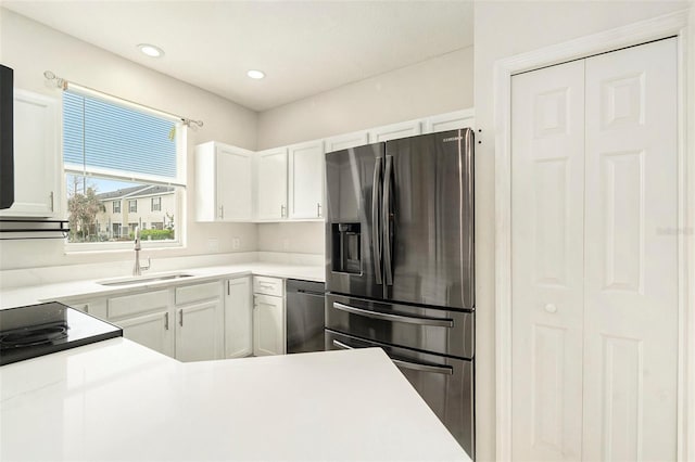 kitchen featuring recessed lighting, light countertops, appliances with stainless steel finishes, white cabinetry, and a sink