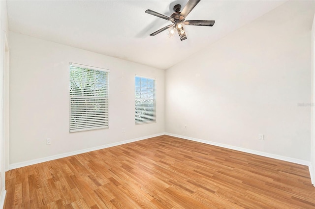 spare room featuring lofted ceiling, baseboards, ceiling fan, and light wood finished floors