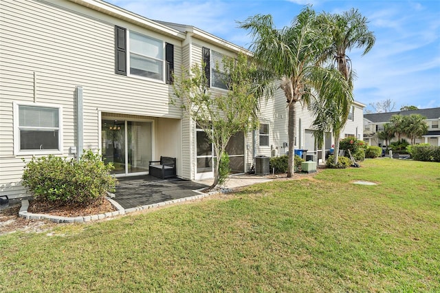 rear view of property with a patio area, a yard, and central air condition unit