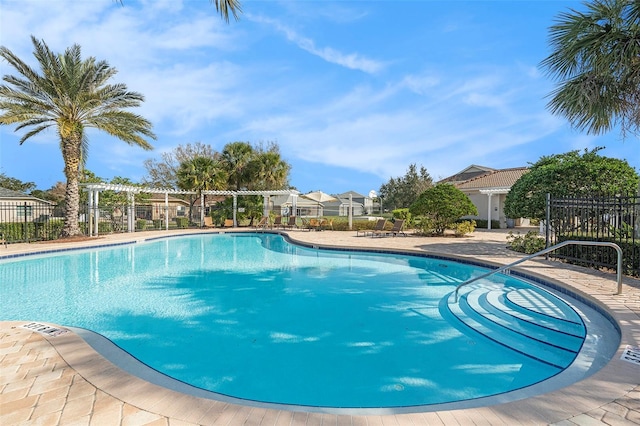 community pool featuring fence, a residential view, and a pergola