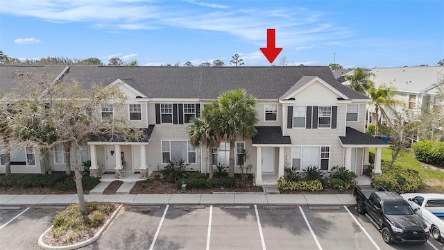 view of property featuring uncovered parking and a residential view