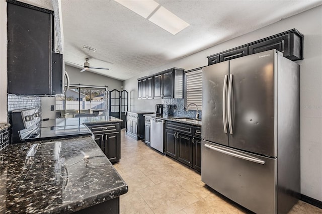 kitchen featuring tasteful backsplash, lofted ceiling, dark stone countertops, stainless steel appliances, and a textured ceiling