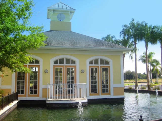 back of property featuring a water view and french doors