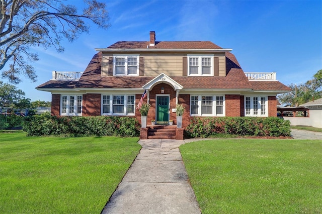 view of front facade featuring a front lawn, a chimney, and brick siding