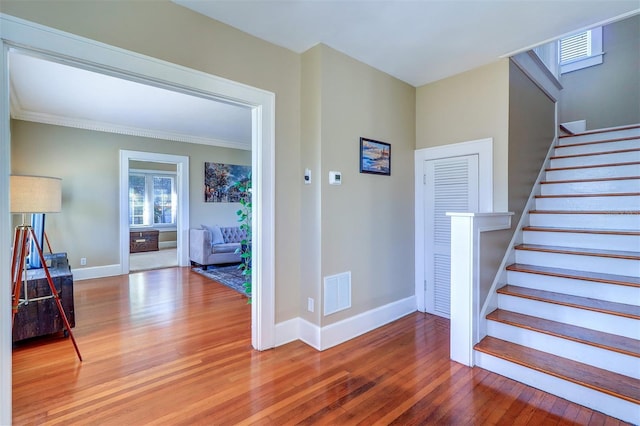 staircase with visible vents, baseboards, and wood finished floors