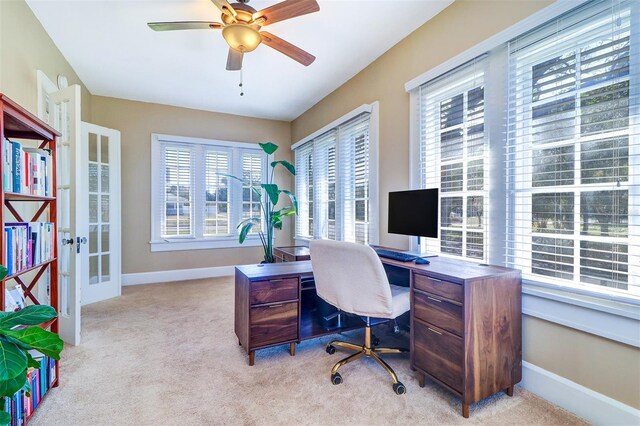 office featuring a ceiling fan, french doors, light carpet, and baseboards