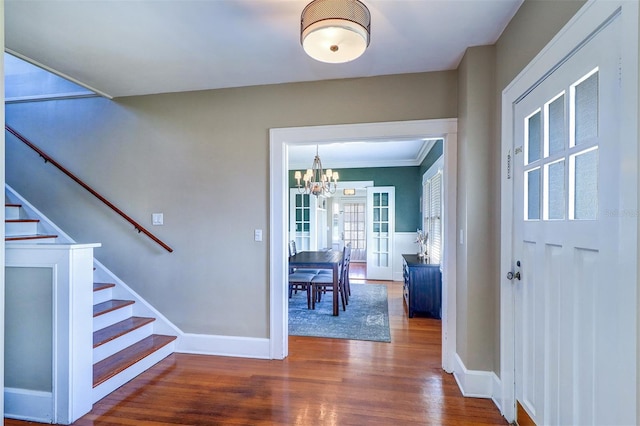 entryway with a chandelier, wood finished floors, baseboards, and stairs