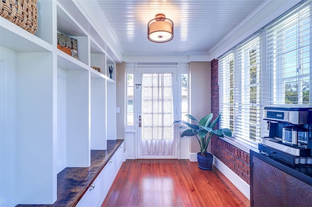 mudroom with crown molding and wood finished floors