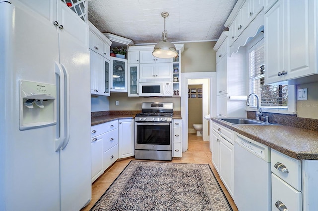 kitchen featuring white appliances, a sink, white cabinetry, open shelves, and dark countertops