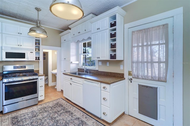 kitchen featuring open shelves, dark countertops, white cabinetry, a sink, and white appliances