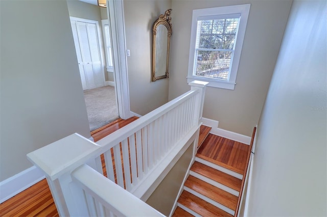 staircase featuring baseboards and wood finished floors