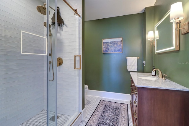 full bathroom featuring a stall shower, toilet, vanity, and baseboards