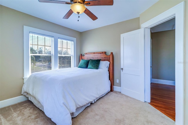 bedroom with light carpet, a ceiling fan, and baseboards