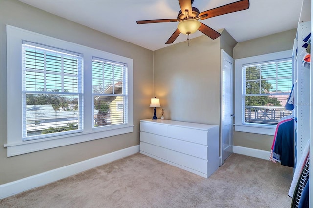 bedroom featuring light colored carpet, baseboards, and multiple windows