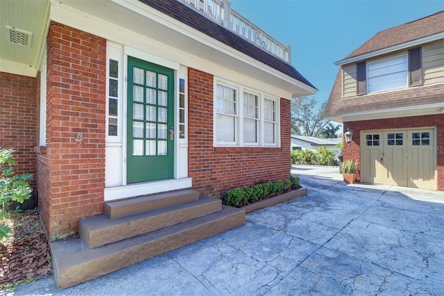 view of exterior entry featuring brick siding