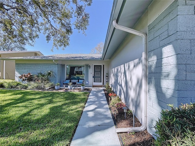 doorway to property with a lawn