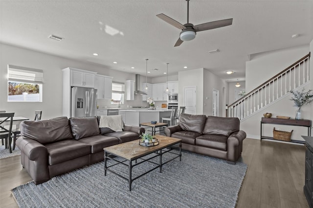 living room with wood-type flooring, a textured ceiling, and ceiling fan