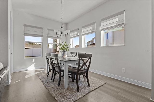 dining room featuring an inviting chandelier, hardwood / wood-style floors, and a healthy amount of sunlight