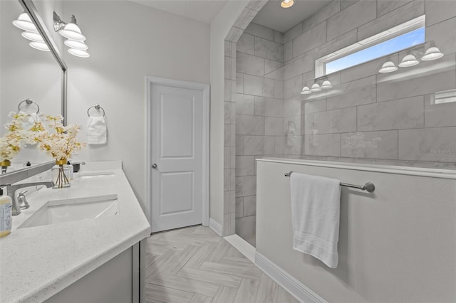 bathroom featuring vanity, tiled shower, and parquet floors