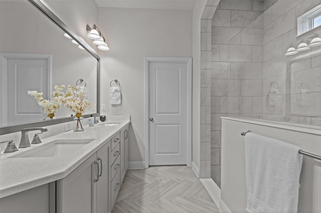 bathroom with parquet floors, tiled shower, and vanity