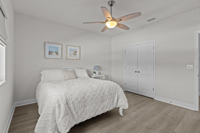 bedroom with ceiling fan, light hardwood / wood-style floors, and a closet