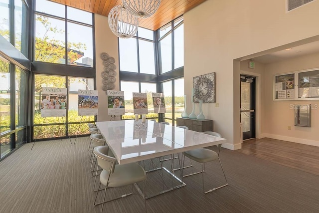 sunroom with a healthy amount of sunlight, wooden ceiling, and a chandelier