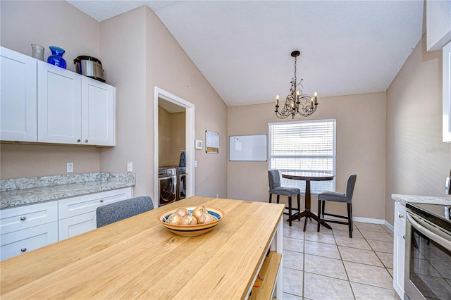 tiled dining room featuring washer and dryer and a chandelier