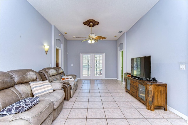 living room with french doors, ceiling fan, a textured ceiling, and light tile patterned floors