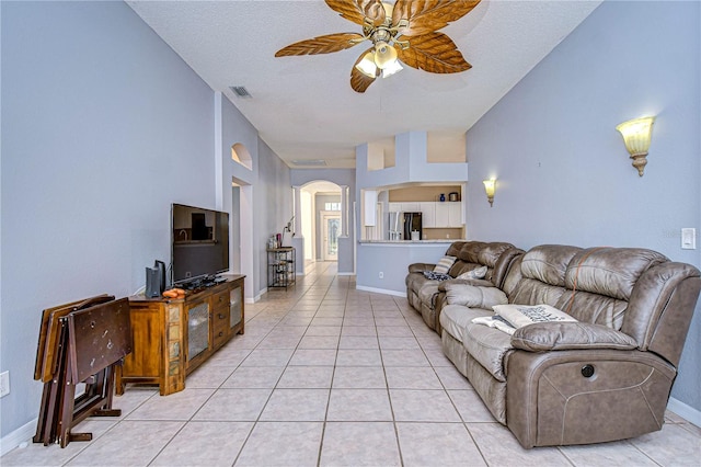 living room with light tile patterned flooring, a textured ceiling, and ceiling fan