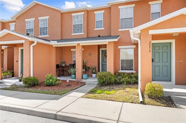 townhome / multi-family property featuring covered porch