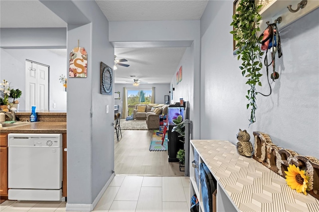 hall featuring light tile patterned floors and a textured ceiling