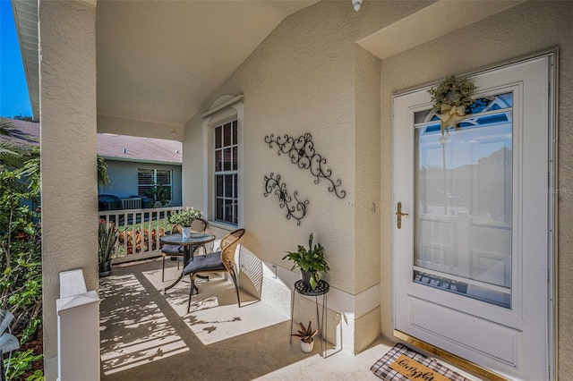 property entrance with a porch and stucco siding