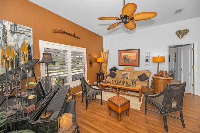 interior space featuring ceiling fan, a textured ceiling, visible vents, and wood finished floors