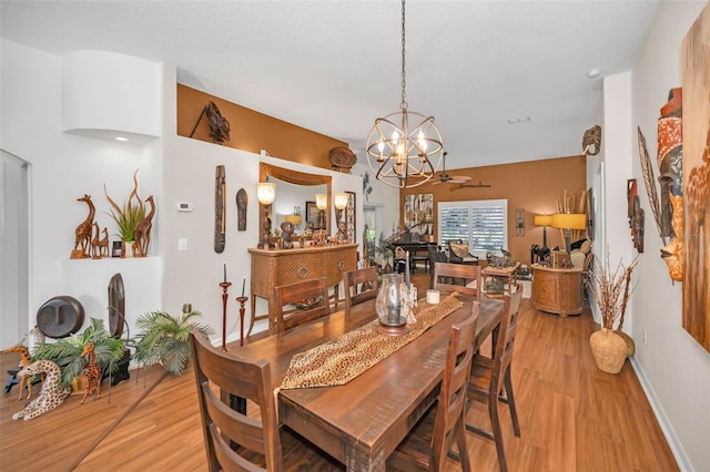 dining area with a notable chandelier, light wood-style flooring, and baseboards