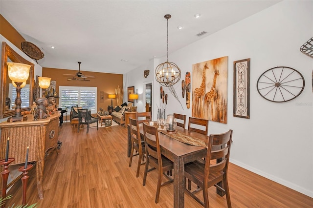 dining room featuring ceiling fan with notable chandelier, light wood-type flooring, visible vents, and baseboards