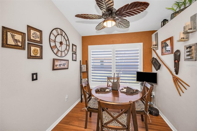 dining area featuring wood finished floors, a ceiling fan, and baseboards