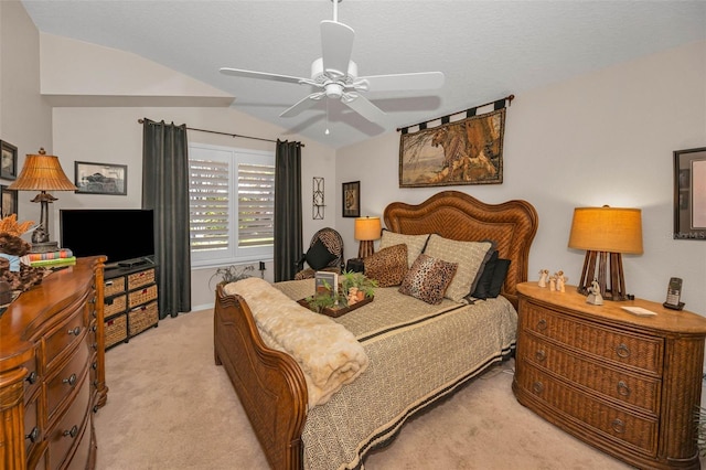 bedroom with vaulted ceiling, a textured ceiling, a ceiling fan, and light colored carpet