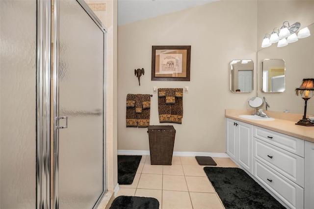 full bath with a stall shower, tile patterned flooring, baseboards, and vanity