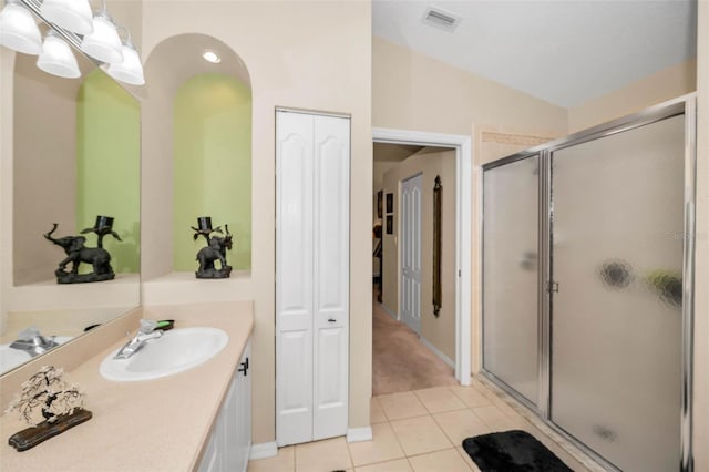 bathroom with lofted ceiling, visible vents, a shower stall, vanity, and tile patterned floors