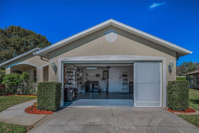 view of front of home featuring concrete driveway, an attached garage, and stucco siding