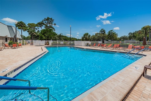 pool with a patio area and fence