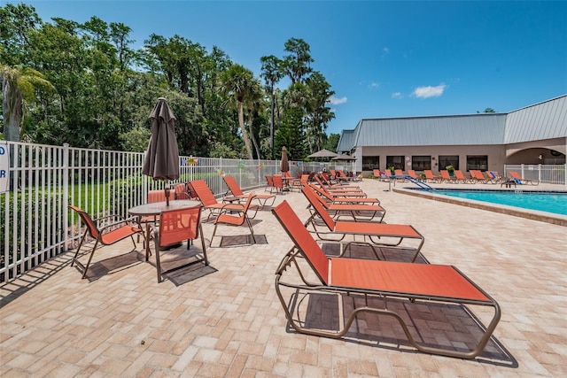 view of patio featuring fence and a community pool