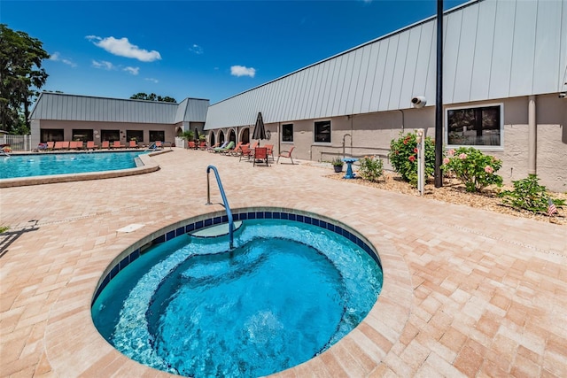 community pool with a community hot tub and a patio area