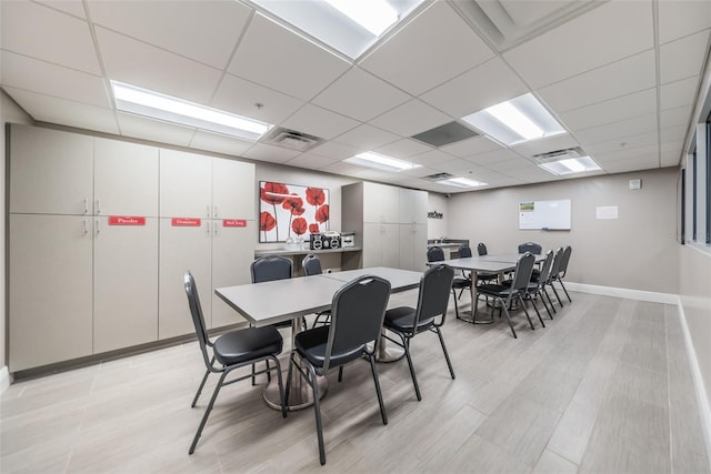 dining space with a paneled ceiling, baseboards, and visible vents