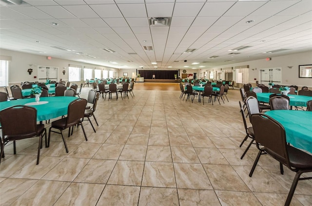 dining space with a paneled ceiling, visible vents, and light tile patterned floors